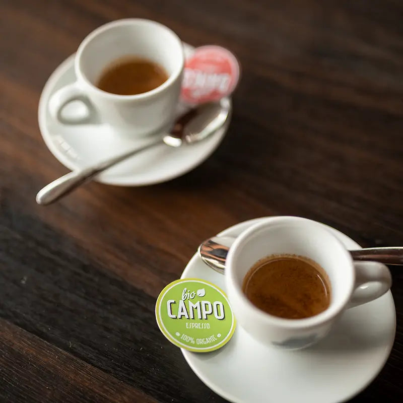 Zwei Espressotassen mit Bio Campo Espresso 100% Organic Kapsel-Etikett
